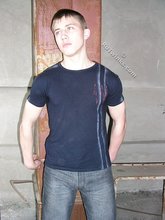 Blue-eyed buff twink posing shirtless and looking smart