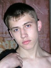 Blue-eyed buff twink posing shirtless and looking smart