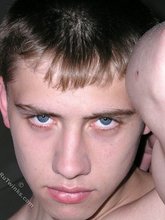 Blue-eyed buff twink posing shirtless and looking smart