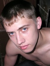 Blue-eyed buff twink posing shirtless and looking smart