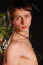 Beautiful-looking twink posing shirtless on a bed
