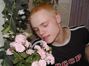 Blond-haired twink drinking and smelling flowers