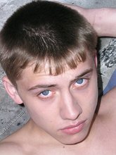 Dark-haired young boy posing in a fetal position