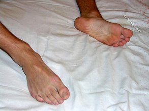 Dark-haired twink fingering his own asshole on a bed