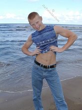 Redheaded guy posing shirtless in the woods