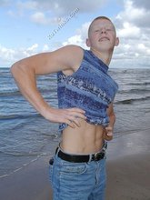 Redheaded guy posing shirtless in the woods
