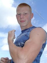 Redheaded guy posing shirtless in the woods