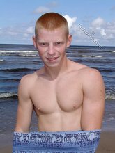 Redheaded guy posing shirtless in the woods