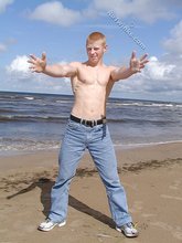 Redheaded guy posing shirtless in the woods