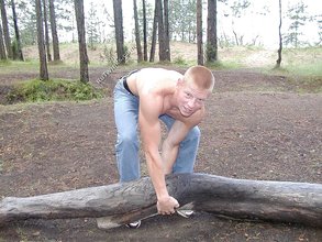 Redheaded guy posing shirtless in the woods