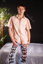 Stylish young boy finally taking his shirt off