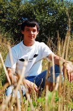 Dark-haired young twink posing in a haystack