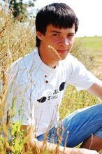 Dark-haired young twink posing in a haystack