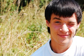 Dark-haired young twink posing in a haystack