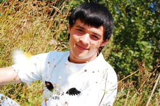 Dark-haired young twink posing in a haystack