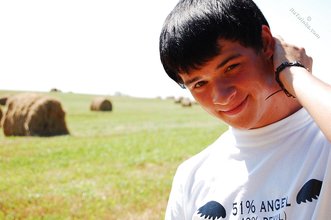 Dark-haired young twink posing in a haystack