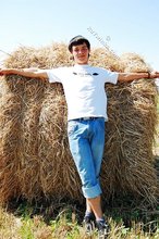 Dark-haired young twink posing in a haystack
