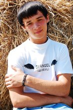 Dark-haired young twink posing in a haystack