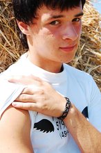 Dark-haired young twink posing in a haystack