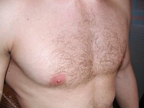 Jacked-up twink posing shirtless by the wall