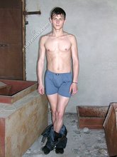 Slender twink posing shirtless in a ruined apartment