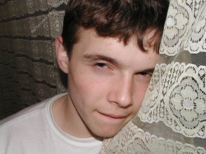 Dark-haired twink shows his feet, his socks, his smile