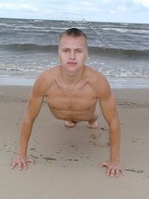 Blond-haired twink happily posing by the water