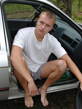 Blond-haired twink happily posing by the water