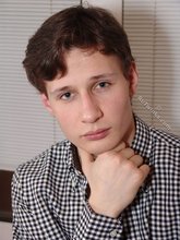 Serious-looking young boy posing shirtless here