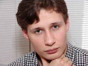 Serious-looking young boy posing shirtless here