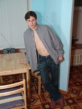 Serious-looking young boy posing shirtless here