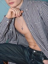 Serious-looking young boy posing shirtless here