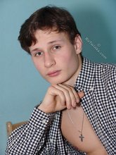 Serious-looking young boy posing shirtless here