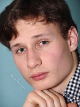 Serious-looking young boy posing shirtless here