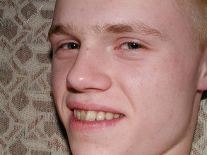 Blond-haired twink stroking that fat cock on a couch