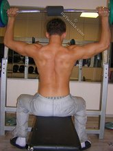 Muscular twink lifting weights in the gym before posing