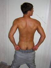 Muscular twink lifting weights in the gym before posing