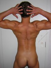 Muscular twink lifting weights in the gym before posing
