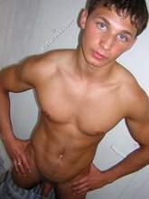 Muscular twink lifting weights in the gym before posing