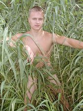 Blond-haired twink posing totally naked in the grass