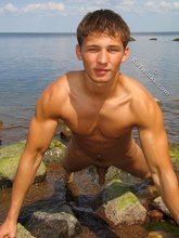 Tanned twink decides to pose naked by the river
