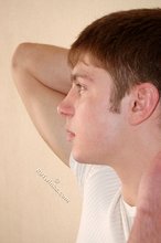 Leggy teen posing sexily with his back against the wall