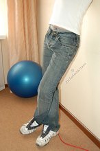 Leggy teen posing sexily with his back against the wall
