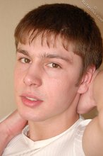 Leggy teen posing sexily with his back against the wall