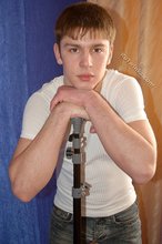 Leggy teen posing sexily with his back against the wall
