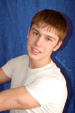Leggy teen posing sexily with his back against the wall