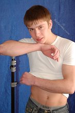 Leggy teen posing sexily with his back against the wall