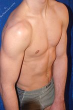 Muscular twink striking sexy poses in a studio