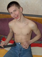 Shirtless twink posing seductively on a dirty sofa