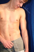 Muscular teen boy taking his jeans off on camera